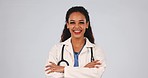 Medical doctor, portrait and a woman in studio with a stethoscope, arms crossed and confident. A happy and friendly female healthcare worker on grey background for wellness, medicine and career pride