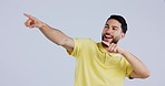 Excited, mockup and man pointing in studio isolated on a white background. Smile, hand gesture and happy person advertising, marketing offer and show direction of commercial copy space on promotion