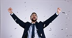 Winner, confetti and business man fist pump in studio for celebration of bonus, payment and deal. Success, excited and portrait of person cheer for winning, promotion and lottery on gray background