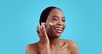 African woman, cream and face in studio, beauty or product for health with thinking by blue background. Girl, model or smile with transformation, glow or cosmetic change with self care for wellness