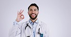 Man, face and ok sign of doctor in studio for success, healthcare feedback and medical trust on white background. Portrait, happy arab surgeon and perfect emoji for support, good review and like icon