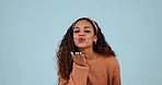 Fashion, blow kiss and face of woman in studio with smile for confidence, love hand gesture and flirting. Emoji, affection and portrait of person with trendy clothes and style on blue background