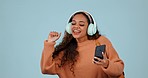 Student, phone and a woman dancing with headphones in studio with internet and backpack. Young person with a smartphone, singing and listening to music or streaming song to relax on a blue background