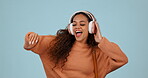 Headphones, dancing and happy woman student with music, radio and isolated in a studio blue background. Happiness, joy and young person streaming audio for energy movement and celebration with smile