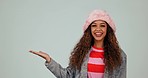 Fashion, open hand and face of woman in studio with trendy hat for deal, promotion and sale. Advertising, mockup and portrait of happy person with style, casual clothes and outfit on gray background