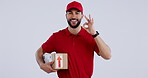 Smile, box and perfect delivery with a man courier in studio on gray background for supply chain logistics. Portrait, post office and hand gesture with a young postal working in the shipping industry