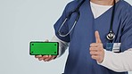 Thumbs up, doctor and green screen of phone, mockup and advertising space, download app and tracking markers in studio. Closeup hands of medical worker, like emoji and mobile news on white background