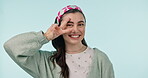 Face, smile and woman with peace in studio for winning, vote and feedback on blue background. Portrait, happy gen z model and hand gesture of v sign, symbol and emoji for freedom, support and hope 