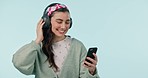 Studio music, phone and dancing happy woman listening, watch or streaming social network video, mobile sound or song. Smile, cellphone and person with podcast, radio or media on blue background