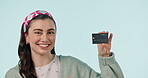 Face, smile and credit card to bank with a woman in studio on blue background for finance or accounting. Portrait, ecommerce or retail with a happy young customer looking to invest in economy growth