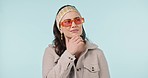 Studio, fashion sunglasses and face of woman thinking about clothes decision, trendy apparel or outfit choice. Problem solving style ideas, apparel plan and person with glasses on blue background