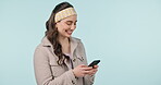 Happy woman, phone and social media in communication or networking against a studio background. Female person smile in happiness, online chatting or texting on mobile smartphone app on mockup space