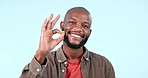 Ok hands, face and man in studio voting for good review, trust or excellence sign on blue background. Portrait, happy african model and perfect for success, agreement or icon of support, yes or emoji