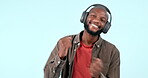Headphones, dancing or happy man streaming music to relax or freedom in studio on blue background. Smile, excited or African person listening to a radio song, sound or audio on an online subscription