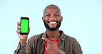 Pointing, green screen or happy black man with mobile discount deal or sale on logo space. Advertising, smile or face of African person with mockup, news or smartphone promotion on blue background 