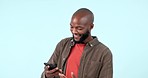Happy, news and black man with phone in studio for social media, sign up or promo on blue background. Smartphone, notification and African guy winner excited with text, alert or online prize giveaway