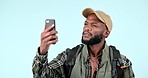 Adventure, phone and man with a backpack in a studio checking signal for online map. Technology, trekking and African male hiker doing research for a camp directions on cellphone by white background.