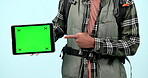 Tablet, green screen and hands of man pointing in studio isolated on a blue background with tracking markers. Technology, mockup space and person advertising hiking, marketing travel and promotion