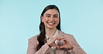 Happy, portrait and a woman in studio with heart hands for business review, love or feedback. Face of young female person with shape, symbol or icon on a blue background for donation, charity or care