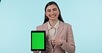 Tablet, green screen and smile with a business woman pointing to mockup on a blue background in studio. Technology, website and a happy young employee showing tracking markers on a screen or display