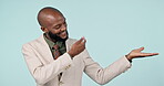 Hand, pointing and a business man in studio for advertising, announcement and mockup space. Happy, corporate and a professional person from Kenya on a blue background with empty palm for choice