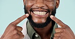 Happy black man, teeth and big smile at dentist for clean oral, gum or mouth care against a studio background. Closeup of African male person pointing in tooth whitening, dental hygiene or healthcare