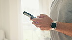 Hands, phone and fitness with a sports person in his home getting ready for training using a smart watch. Mobile, social media and app for fitness tracking with an athlete closeup in his apartment