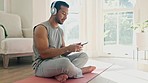 Man, yoga fitness and headphones for wellness music, audio streaming and home workout, calm or peace on floor. Young person on mobile, listening to mindfulness, meditation or zen audio in training