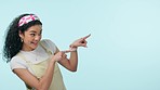 Pointing, talking gesture and a woman on a blue background for communication, excited and conversation. Calling, happy and a young girl or person with attention and speaking on a mockup backdrop