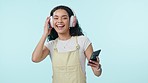 Dance, music and happy woman on headphones on mobile in studio isolated on a blue background mockup space. Radio, smile and person on phone moving to audio, listening to sound and hearing hip hop.