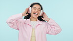 Dance, music and excited woman on headphones in studio isolated on a blue background. Radio, happy person moving to audio and listening to sound, hearing hip hop for freedom or streaming media online