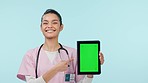 Nurse, woman and tablet green screen, yes for healthcare and clinic presentation, advice or news on a blue background. Young doctor or medical student with digital mockup, tracking marker and studio