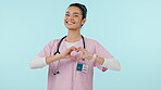 Nurse, heart hands and face, healthcare and woman in cardiology with support isolated on blue background. Portrait, wellness and health with love sign, care and emoji with caregiver in studio