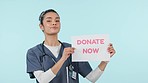 Face, donate now and doctor with a board, woman and billboard on a blue studio background. Portrait, person and medical professional with a poster, donation and charity with volunteer and healthcare