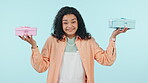 Face, gift or happy woman confused by choice or option isolated on blue background in studio. Box, present or portrait of uncertain person with doubt, decision confusion or dont know with smile