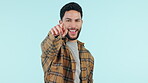 Hand, pointing and man with recruitment of you in college, opportunity or invitation with a smile on face for decision on blue background. Student, accountability and gesture to show a choice