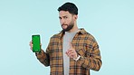 Man, phone green screen and no for wrong decision, warning and social media mistake in studio. Young person on mobile mockup, bad review and disagree face with tracking marker on a blue background