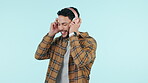 Headphones, music and happy man dance in studio isolated on a blue background mockup space. Smile, radio and person moving with energy to audio, hearing sound or streaming media online for listening