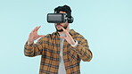 Virtual reality, future and goggles with a man using technology in studio on a blue background. Metaverse, software and 3D gaming with a young person playing esports in cyberspace using an AR app