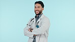 Medical doctor, portrait and a man arms crossed in studio with confidence, career pride or trust. Happy, face and Arab healthcare worker on blue background for specialist consultation and medicine