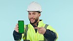 Construction man, green screen and point phone in studio, app promo and face by blue background. Engineer, maintenance employee and ux presentation with smartphone mockup, tracking markers and space