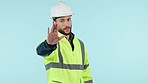 Face, man and engineer with stop, warning and safety regulations on a blue studio background. Portrait, person and construction worker with hand gesture, deny and forbidden with rejection and helmet