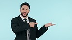 Happy businessman, pointing and advertising product, deal or sale discount against a studio background. Portrait of male person or business employee show notification, alert or marketing on mockup