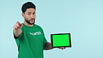 Green screen, volunteer and man with tablet mockup in studio pointing at you for website. Portrait of person with technology on blue background for charity donation, announcement or tracking markers