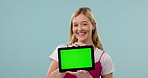 Happy woman, face or green screen on a tablet for social media advertising or online branding. Blue background, smile or portrait of gen z student showing app chroma key or mockup space in studio