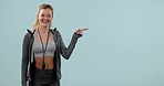 Fitness, face smile and woman pointing at mockup space in studio isolated on a blue background. Portrait, happy athlete advertising and marketing workout of coach or promotion of personal trainer