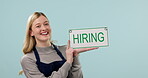 Hiring sign, woman and face, advertising job and opportunity for work with cafe owner isolated on blue background. Small business, recruitment and offer with board, search for employees in studio