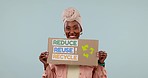 Recycle sign, black woman and face with smile and climate chance, ecology and earth day message. Cardboard, poster and placard to support the planet from global warming with blue background in studio