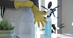 Person, hands and gloves in housekeeping, hygiene or cleaning with spray bottle or detergent on table. Closeup of maid, cleaner or domestic getting ready for disinfection, bacteria or germ removal