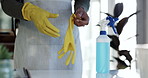Person, hands and gloves in housekeeping, cleaning or hygiene with spray bottle or detergent on table. Closeup of maid, cleaner or domestic getting ready for disinfection, bacteria or germ removal